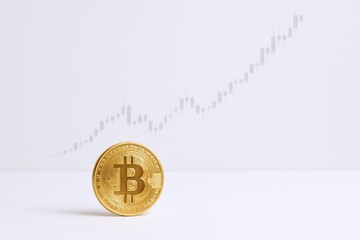 Golden bitcoin coin with an upward trending financial chart on a clean white background.