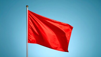 Red flag waving against a light blue sky