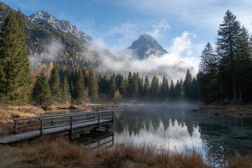Misty mountain lake with wooden boardwalk