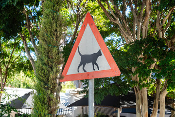 Ein dreieckiges Warnschild mit einer schwarzen Katze, das auf freilaufende Katzen in Barrydale...