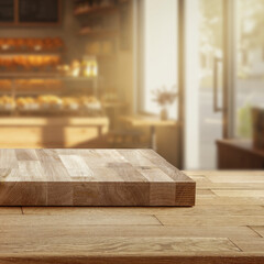 Wooden table with pedestal for product display in warm sunlit bakery interior – background with...