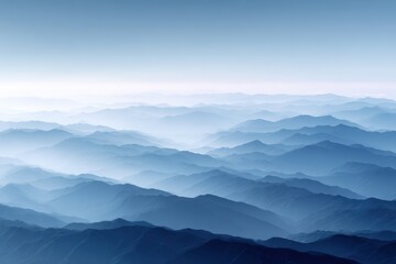 Serene mountain landscape with layered blue hues and soft mist, creating a tranquil atmosphere in the vast wilderness of nature's beauty