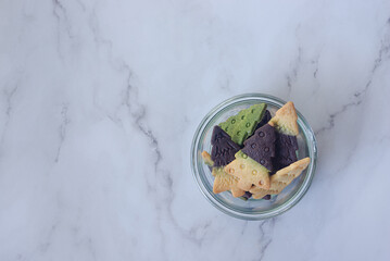 Two toned Christmas tree shaped shortbread cookies in a glass bowl. Chocolate and vanilla butter...