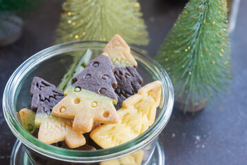 Two toned Christmas tree shaped shortbread cookies in a glass bowl. Chocolate and vanilla butter...