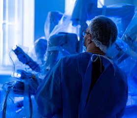Robotic surgery at a clinic. A surgeon operates robotic equipment in a high-tech surgical room,...