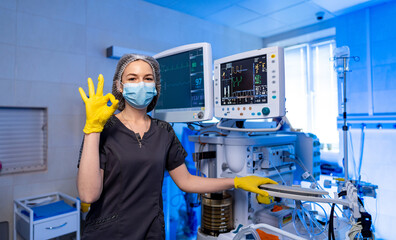 Healthcare pro shows positivity. A gloved, masked healthcare worker gives a thumbs up next to...