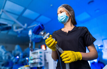 Doc readies for procedure. A healthcare worker in scrubs and gloves is readying medical equipment...