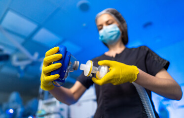 Med pro sets up hospital gear. A healthcare worker in PPE adjusts a medical device in a hospital,...