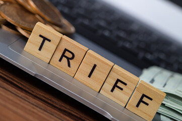 Scrabble Tiles Forming the Word Tariff on a Laptop with Coins