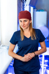 Daytime clinic medical staff. A healthcare worker stands confidently in a clinic with equipment in...