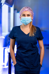 Medical healthcare worker. A young healthcare worker stands confidently in scrubs with a mask and...