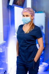 Medico in scrubs and mask. In a medical facility, a healthcare professional poses confidently while...