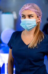 Dedicated healthcare worker. A healthcare worker wearing a mask and cap looks focused in a clinical...