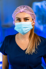 Masked health worker in cap. A healthcare worker is wearing a surgical mask and a hair cap,...