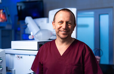 Smiling doctor in surgery room. A confident medical expert in scrubs exudes warmth and...