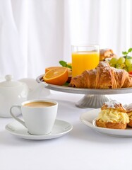 Minimalist breakfast with cappuccino, orange juice, halved oranges, and sugar-dusted pastries on a glossy white surface in soft natural light.