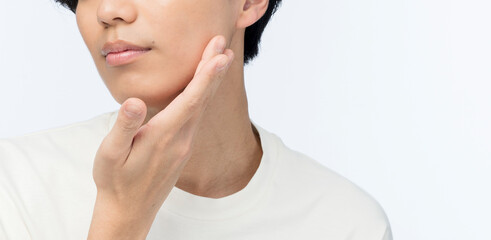 頬に手を当てている若い日本人男性