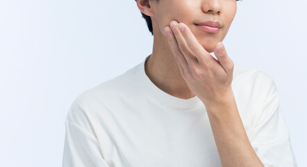 頬に手を当てている若い日本人男性