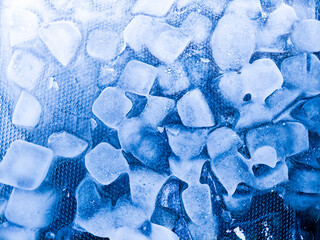 Top view of transparent ice cubes arranged neatly. Background with ice cubes. The background blue...