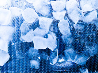 Top view of transparent ice cubes arranged neatly. Background with ice cubes. The background blue...