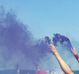 A person is holding a purple smoke bomb