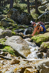 Mother and child crouching in a stream