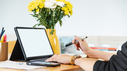 Businesswoman sitting working using stylus pen and digital tablet working on laptop computer at home in relaxed pose working business communication online female student studying online e-learning