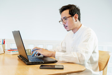 Man typing on laptop at desk, side view for telework, online, man, businessman and laptop screen in home office for articles, business news and data transmission.