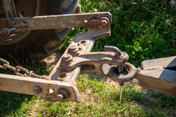 A close up of a rusty chain attached to a tractor