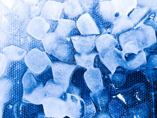 Top view of transparent ice cubes arranged neatly. Background with ice cubes. The background blue...