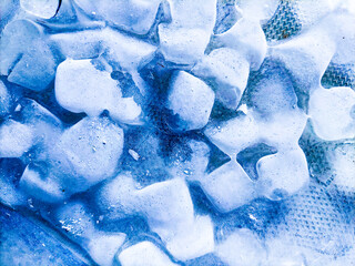 Top view of transparent ice cubes arranged neatly. Background with ice cubes. The background blue...