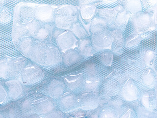 Top view of transparent ice cubes arranged neatly. Background with ice cubes. The background blue...
