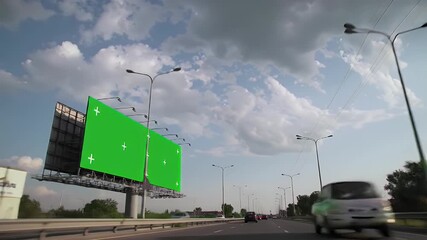 Highway Billboard with Dual Green Screen Panels for Advertising Mockup and Digital Content Insertion, Seen from a Moving Vehicle on a Cloudy Day