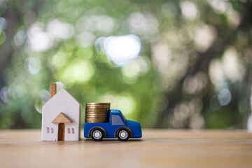 Stacking coins on wood car and house model. Save and investing for buying a house concept for the...