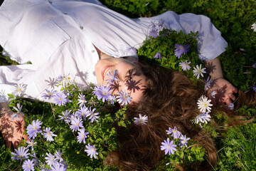 Naklejka premium A Woman Lying Peacefully in a Field of Flowers Experiencing a Tranquil Moment in Nature