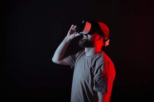 Fototapeta A man is wearing a VR headset as he becomes deeply engaged in an incredibly immersive virtual reality experience