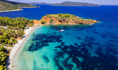 Greece travel, green picturesque Sporades. Alonissos island beast scenic beaches - Kokkinokastro aerial drone view of oragnge rocks and turquoise sea