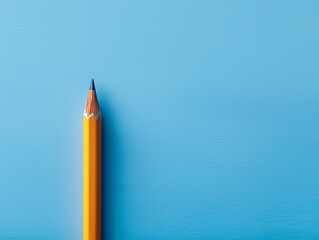 Vertical yellow pencil standing on blue background