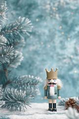 Festive nutcracker doll standing on snow. Winter celebration scene with frosted fir tree branches. Holiday decoration for Christmas or New Year.
