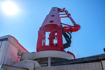 Low angle view of base with boom of concrete mixer crane carrying with concrete discharge hose, clear blue sky, a sunny day in the Netherlands