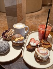 Assorted artisan brunch dishes served with hot coffee and iced fruit juice in a cozy café setting