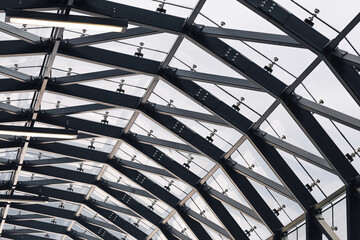 Modern steel and glass roof. Geometric structure with arched beams. Transparent ceiling design in...