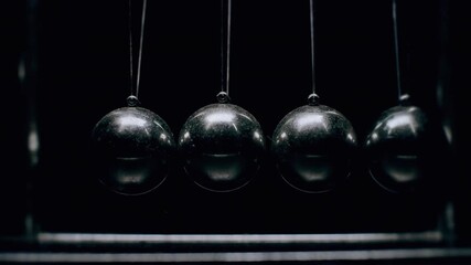 Newtons cradle demonstrating conservation of momentum in motion - Powered by Adobe
