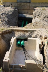 Kabel werden unter einer Straße in einen Schacht geführt