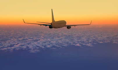 Airplane flying over tropical sea at sunset