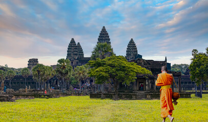Obraz premium Asian monk waling on the green grass and look to Angkor wat in Siem Reap, Cambodia