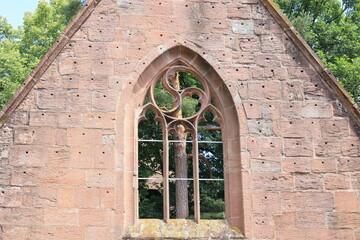 Baumstamm durch ein Fenster der Klosterruine Bad Herrenalb fotografiert