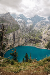 Crystal-Blue Oeschinensee Amid Snow-Capped Alpine Giants, Majestic Turquoise Lake Nestled Among Towering Mountains