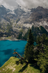 Crystal-Blue Oeschinensee Amid Snow-Capped Alpine Giants, Majestic Turquoise Lake Nestled Among Towering Mountains