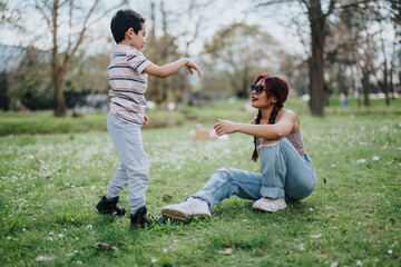 A mother and her child interact joyfully in a beautiful park surrounded by greenery. Bright...